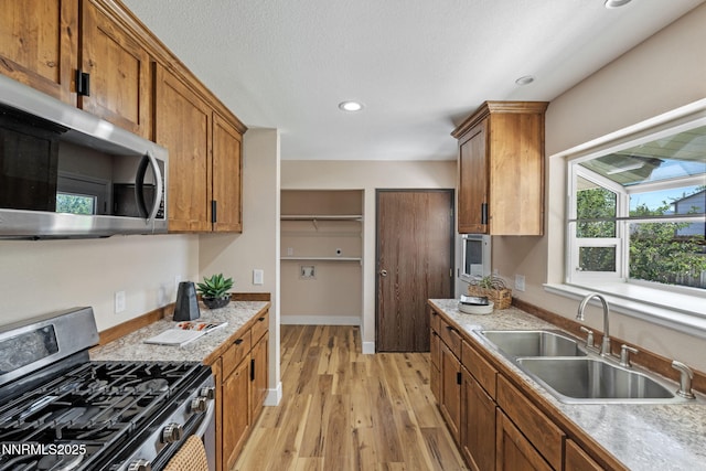 295 Sandia Dr, Fernley, NV 89408 - kitchen with stainless steel appliances, a sink, light wood finished floors, recessed lighting, and brown cabinets