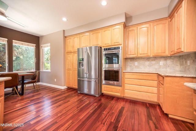 867 Mahogany Dr, Minden, NV 89423 - kitchen featuring appliances with stainless steel finishes, light brown cabinets, dark wood-style floors, light stone counters, and baseboards