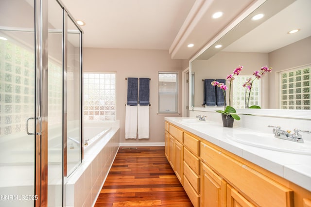 867 Mahogany Dr, Minden, NV 89423 - bathroom featuring wood finished floors, double vanity, plenty of natural light, a garden tub, and recessed lighting
