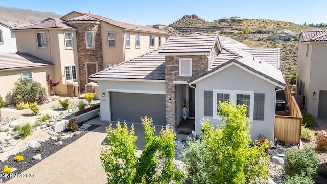 1536 Elk Run Trl, Reno, NV 89523 - view of front of house featuring stone siding, stucco siding, driveway, a garage, and a mountain view