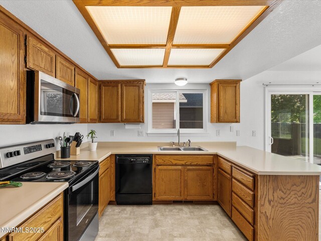 1772 Shamrock Cir, Minden, NV 89423 - kitchen with appliances with stainless steel finishes, a sink, a peninsula, light countertops, and brown cabinetry