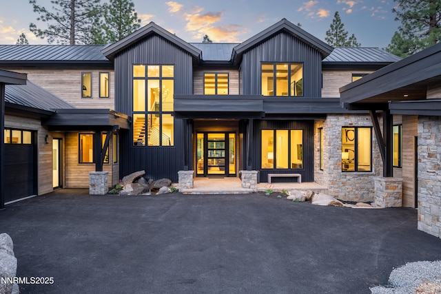 3574 Knob Point Trl, Carson City, NV 89705 - rear view of house with asphalt driveway, metal roof, stone siding, and board and batten siding