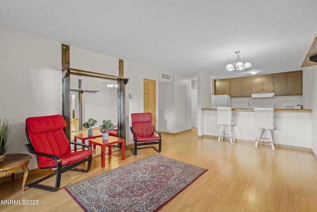 2700 Plumas St Apt 107, Reno, NV 89509 - sitting room featuring a chandelier, light wood-style floors, and baseboards