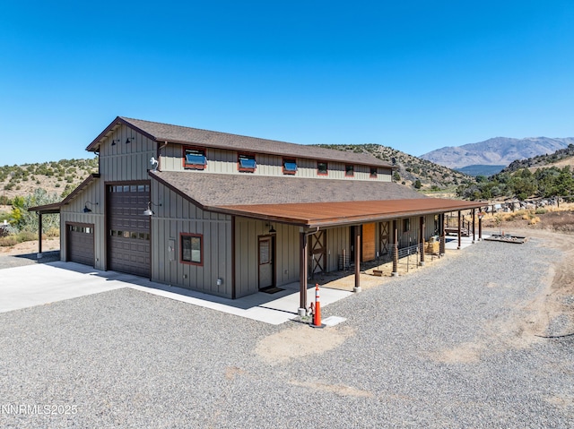 2620 Old Ranch Rd, Gardnerville, NV 89410 - view of front facade with board and batten siding, a mountain view, a shingled roof, and a garage