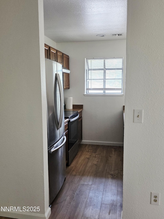 2205 Kietzke Ln Unit E, Reno, NV 89502 - kitchen featuring appliances with stainless steel finishes, dark wood finished floors, under cabinet range hood, a textured ceiling, and baseboards