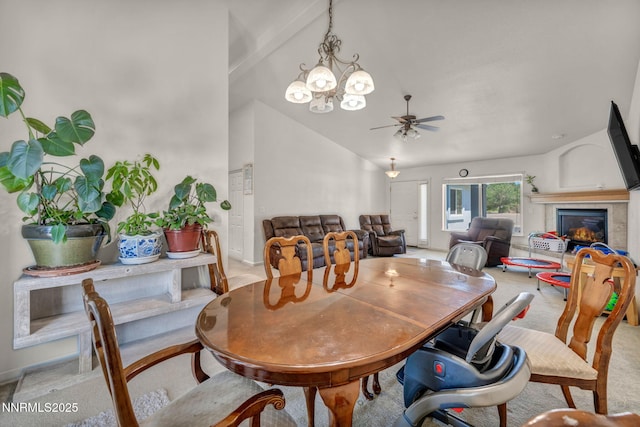 753 Divot Dr, Fernley, NV 89408 - dining area with vaulted ceiling, light colored carpet, a ceiling fan, a glass covered fireplace, and a chandelier