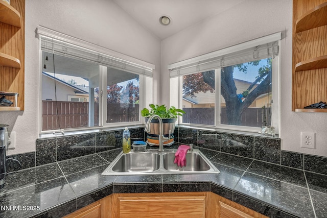 753 Divot Dr, Fernley, NV 89408 - kitchen view of open shelves, a sink, a textured wall, decorative backsplash, and tile counters