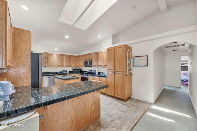 753 Divot Dr, Fernley, NV 89408 - kitchen featuring tile counters, appliances with stainless steel finishes, arched walkways, a peninsula, and recessed lighting