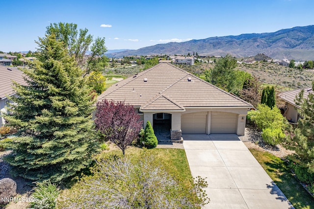 8890 Chipshot Trl, Reno, NV 89523 - ranch-style home featuring stucco siding, a garage, a tile roof, driveway, and a mountain view