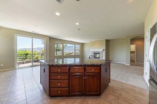 8890 Chipshot Trl, Reno, NV 89523 - kitchen with arched walkways, baseboards, open floor plan, light colored carpet, and recessed lighting