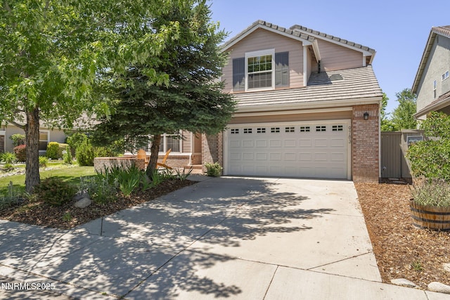 9783 Northrup Dr, Reno, NV 89521 - view of front facade featuring brick siding, a tiled roof, driveway, and an attached garage