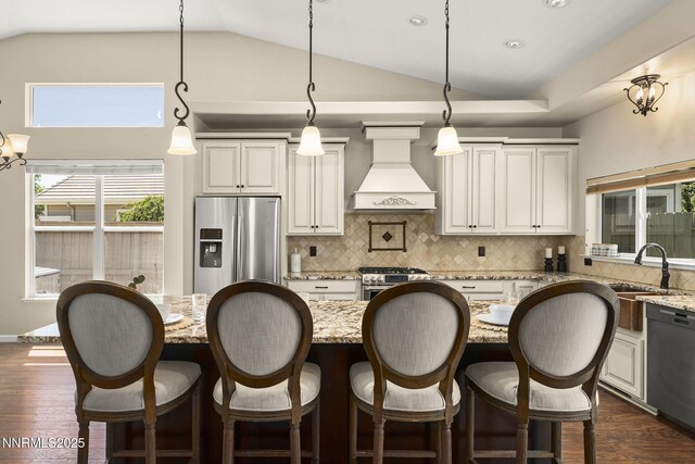 9783 Northrup Dr, Reno, NV 89521 - kitchen featuring stainless steel appliances, custom exhaust hood, decorative backsplash, dark wood-type flooring, and decorative light fixtures