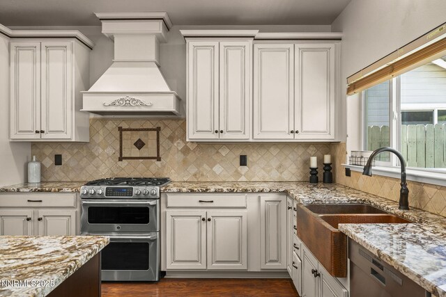 9783 Northrup Dr, Reno, NV 89521 - kitchen featuring appliances with stainless steel finishes, custom exhaust hood, light stone countertops, and dark wood finished floors