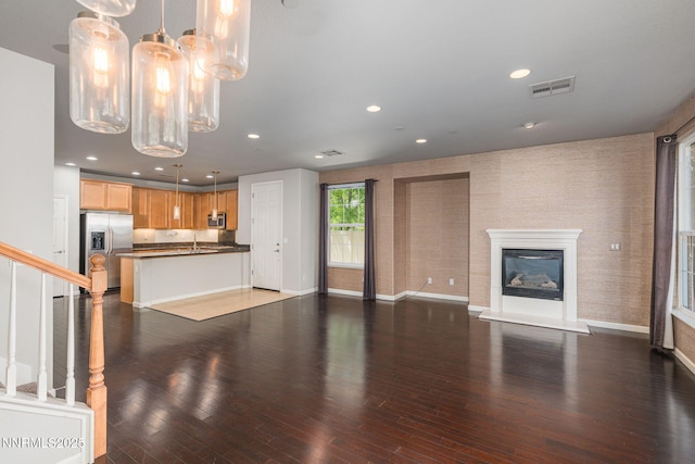 1875 Wind Ranch Rd Unit A, Reno, NV 89521 - unfurnished living room featuring wood finished floors, recessed lighting, a chandelier, baseboards, and a glass covered fireplace