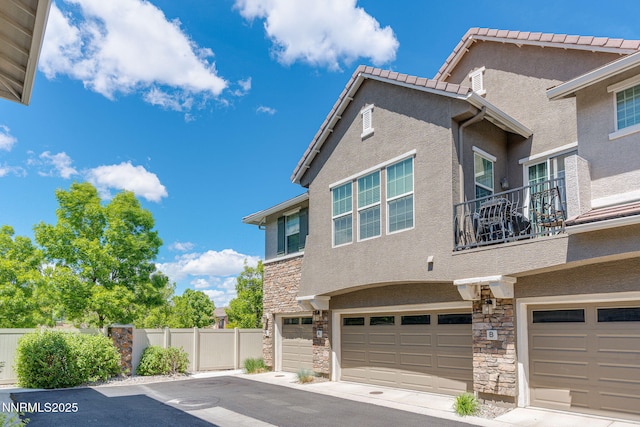 1875 Wind Ranch Rd Unit A, Reno, NV 89521 - view of home's exterior featuring stone siding, stucco siding, an attached garage, and a balcony