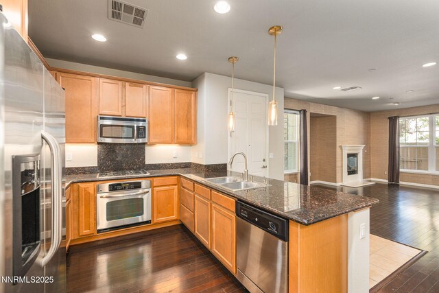 1875 Wind Ranch Rd Unit A, Reno, NV 89521 - kitchen with appliances with stainless steel finishes, a sink, open floor plan, a peninsula, and dark wood-style flooring