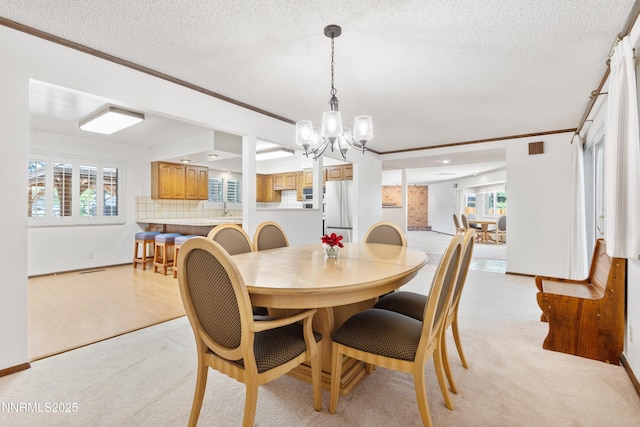 2196 Pebble Beach Dr, Reno, NV 89502 - dining area with ornamental molding, a chandelier, healthy amount of natural light, light colored carpet, and a textured ceiling
