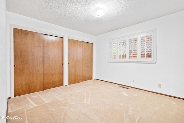 2196 Pebble Beach Dr, Reno, NV 89502 - unfurnished bedroom with multiple closets, a textured ceiling, carpet floors, and baseboards