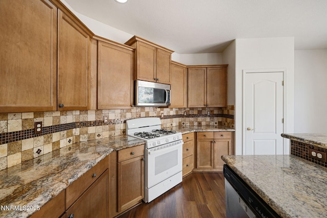 7145 Beacon Dr, Reno, NV 89506 - kitchen with appliances with stainless steel finishes, dark wood finished floors, light stone counters, decorative backsplash, and recessed lighting