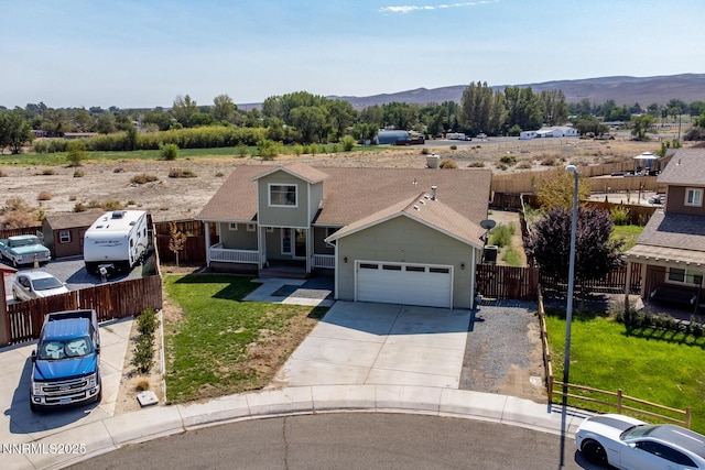 211 Jimmys Peak Ct, Fernley, NV 89408 - view of front of home featuring an attached garage, concrete driveway, a mountain view, and covered porch