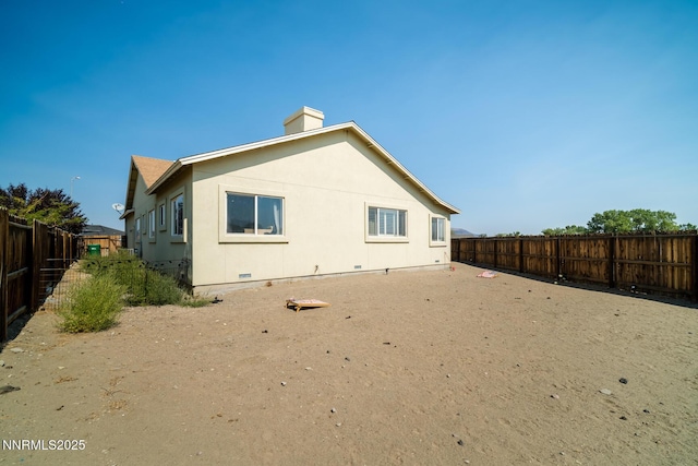 211 Jimmys Peak Ct, Fernley, NV 89408 - rear view of property featuring a fenced backyard, a chimney, and stucco siding