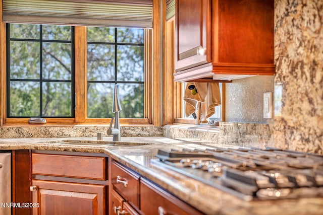 4215 Wild Eagle Ter, Reno, NV 89511 - kitchen with stainless steel gas cooktop, light stone counters, and brown cabinetry