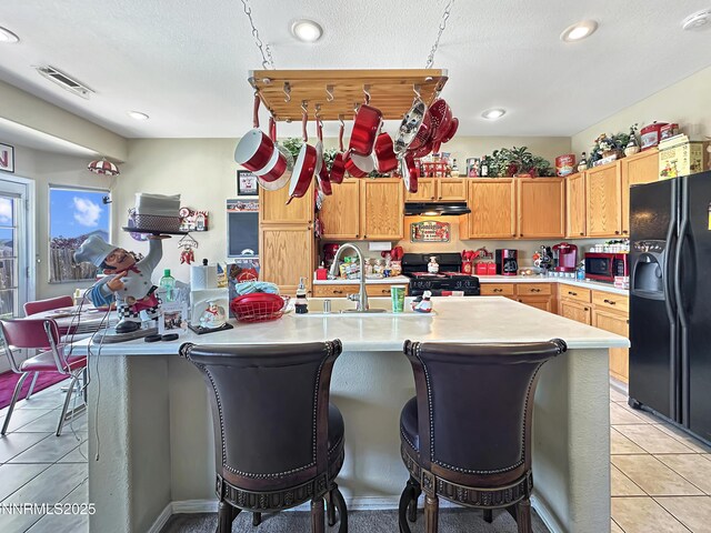 8490 Coral Reef Dr, Reno, NV 89506 - kitchen with black appliances, under cabinet range hood, light countertops, a sink, and recessed lighting