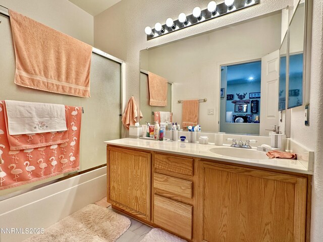8490 Coral Reef Dr, Reno, NV 89506 - bathroom with vanity, combined bath / shower with glass door, a textured wall, and wood finished floors