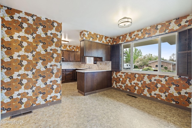 1495 Lillian Way, Reno, NV 89509 - kitchen with light countertops, a sink, backsplash, a peninsula, and dark brown cabinets