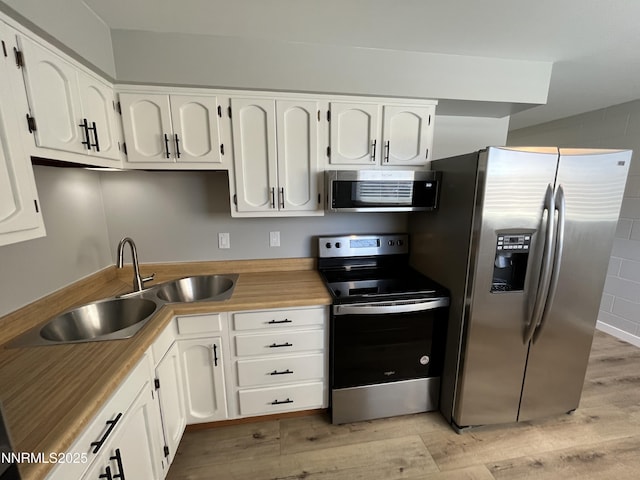 1140 S Curry St, Carson City, NV 89703 - kitchen featuring appliances with stainless steel finishes, a sink, light wood finished floors, and white cabinetry