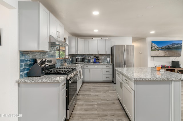 8725 Paloma Way, Reno, NV 89506 - kitchen with stainless steel appliances, under cabinet range hood, recessed lighting, light wood-style flooring, and a center island