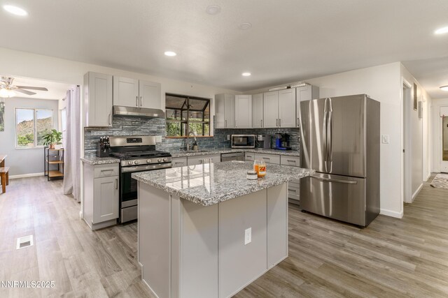8725 Paloma Way, Reno, NV 89506 - kitchen with appliances with stainless steel finishes, under cabinet range hood, plenty of natural light, gray cabinetry, and recessed lighting