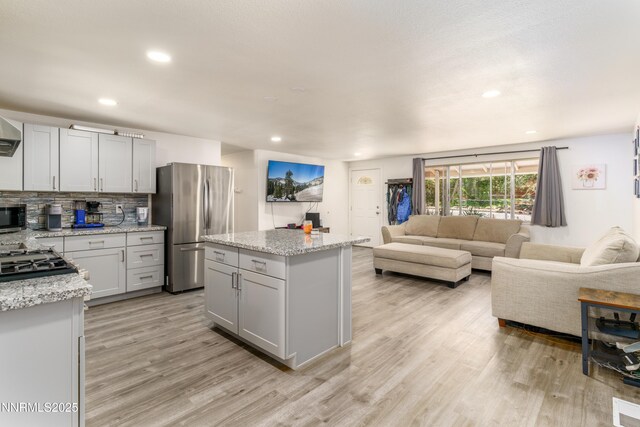 8725 Paloma Way, Reno, NV 89506 - kitchen featuring stainless steel appliances, light wood finished floors, gray cabinets, backsplash, and a kitchen island