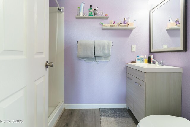 8725 Paloma Way, Reno, NV 89506 - full bathroom with vanity, wood finished floors, toilet, a shower, and baseboards