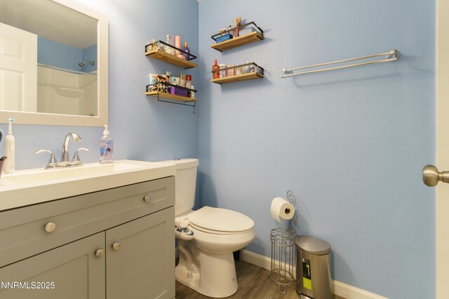 8725 Paloma Way, Reno, NV 89506 - bathroom with toilet, vanity, wood finished floors, baseboards, and a shower