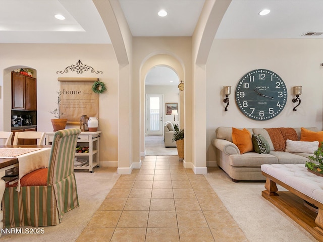 7693 Stone Bluff Way, Reno, NV 89523 - living area featuring arched walkways, light colored carpet, recessed lighting, light tile patterned floors, and baseboards