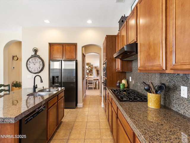 7693 Stone Bluff Way, Reno, NV 89523 - kitchen featuring stainless steel appliances, under cabinet range hood, arched walkways, a sink, and brown cabinets