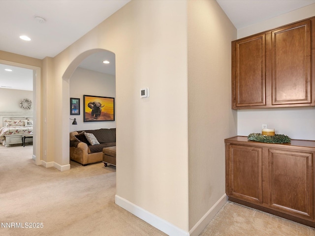 7693 Stone Bluff Way, Reno, NV 89523 - hallway featuring light colored carpet, arched walkways, baseboards, and recessed lighting
