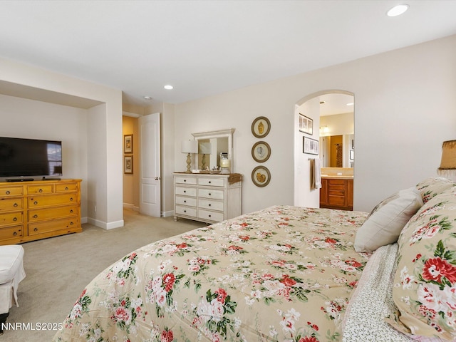 7693 Stone Bluff Way, Reno, NV 89523 - bedroom featuring arched walkways, light colored carpet, recessed lighting, connected bathroom, and baseboards