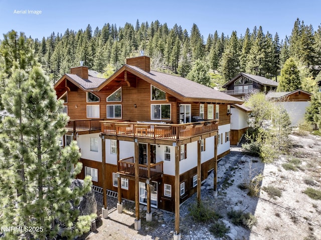 1314 Saint Gallen Ct, Incline Village, NV 89451 - back of house with a chimney, a forest view, and a balcony