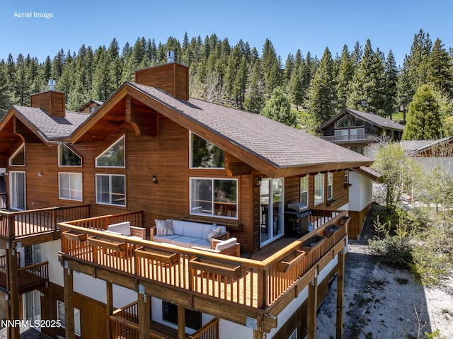 1314 Saint Gallen Ct, Incline Village, NV 89451 - back of property featuring a chimney, roof with shingles, an outdoor living space, a wooded view, and a deck