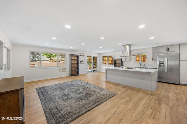 1901 S Marsh Ave, Reno, NV 89509 - kitchen with stainless steel refrigerator with ice dispenser, island range hood, light countertops, light wood finished floors, and a sink