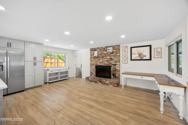 1901 S Marsh Ave, Reno, NV 89509 - unfurnished living room with light wood-style floors, a brick fireplace, recessed lighting, and baseboards