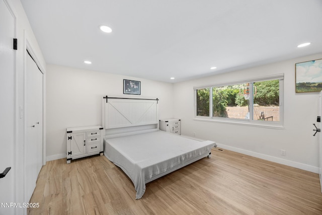 1901 S Marsh Ave, Reno, NV 89509 - bedroom with light wood-style flooring, baseboards, recessed lighting, a closet, and a barn door