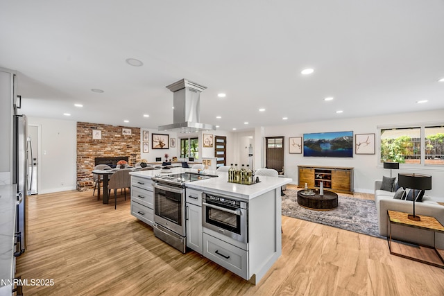 1901 S Marsh Ave, Reno, NV 89509 - kitchen with stainless steel range with electric stovetop, open floor plan, gray cabinets, light countertops, and light wood-type flooring