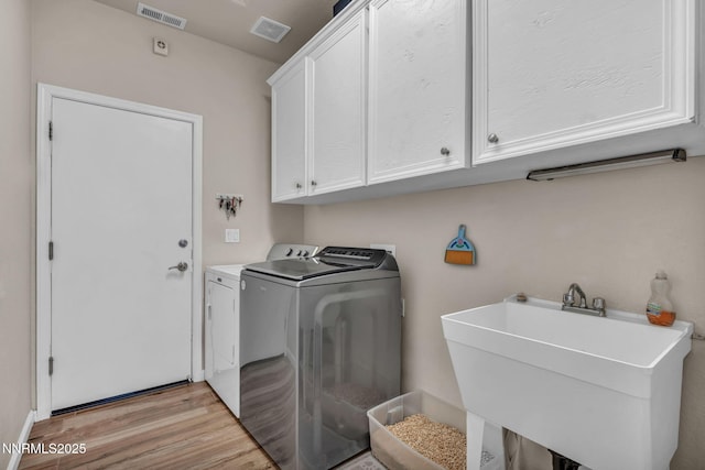 1771 Walnut Dr, Fernley, NV 89408 - laundry area featuring washing machine and dryer, cabinet space, and light wood-type flooring