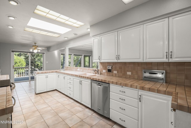 1405 Dartmouth Dr, Reno, NV 89509 - kitchen with stainless steel dishwasher, tile countertops, white cabinetry, light tile patterned floors, and recessed lighting