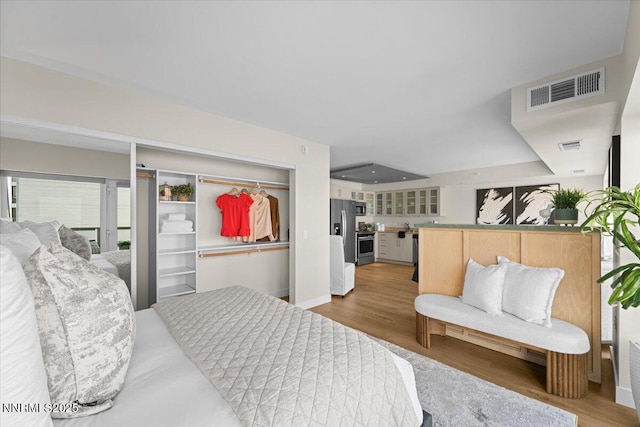 255 N Sierra St Unit 1410, Reno, NV 89501 - bedroom featuring stainless steel refrigerator with ice dispenser, wood finished floors, and baseboards