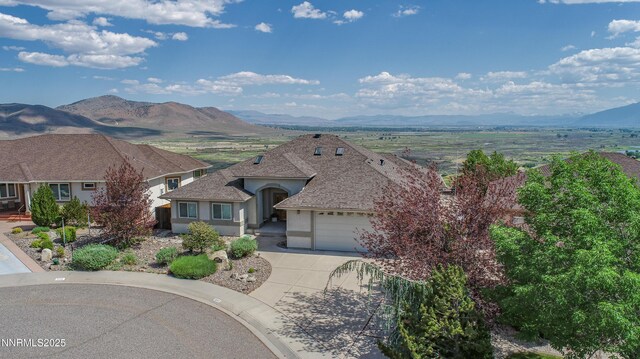 1037 Haystack Dr, Carson City, NV 89705 - view of front facade featuring stucco siding, a mountain view, driveway, and a garage