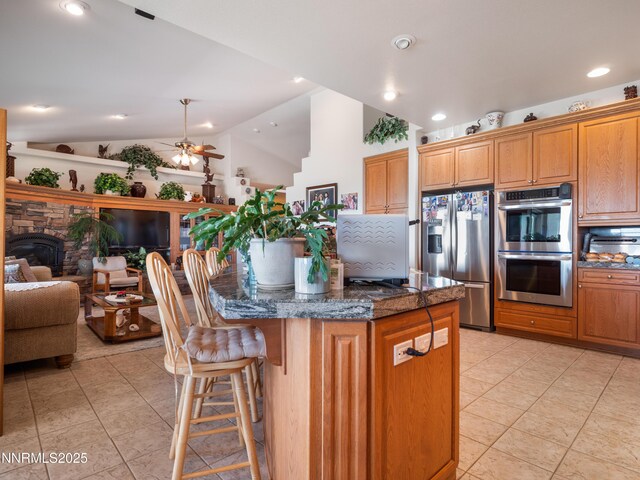 1037 Haystack Dr, Carson City, NV 89705 - kitchen featuring appliances with stainless steel finishes, lofted ceiling, a center island, open floor plan, and light tile patterned floors
